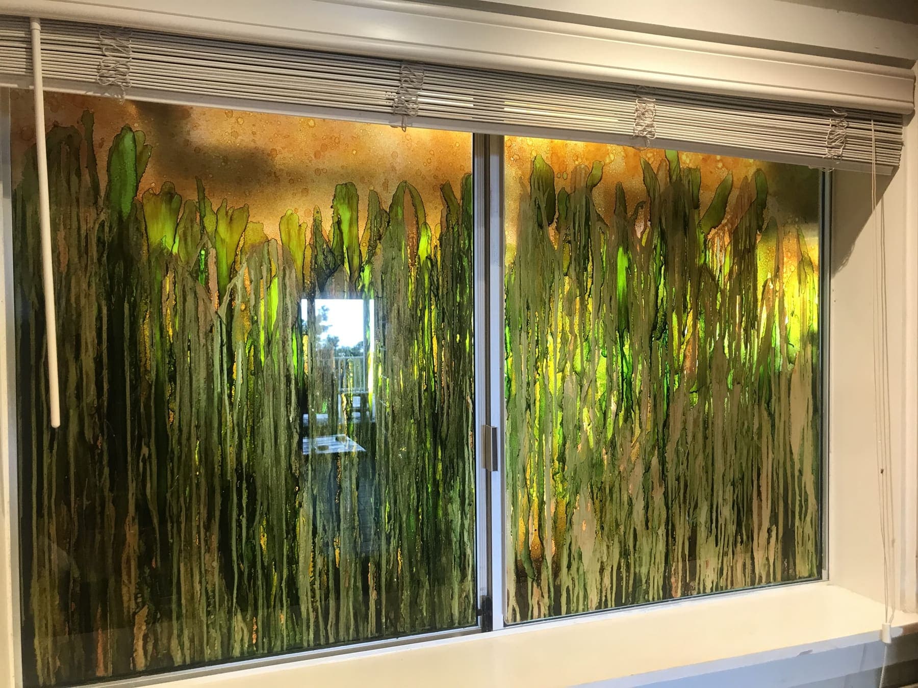 Sliding windows covered in green and gold alcohol ink art
